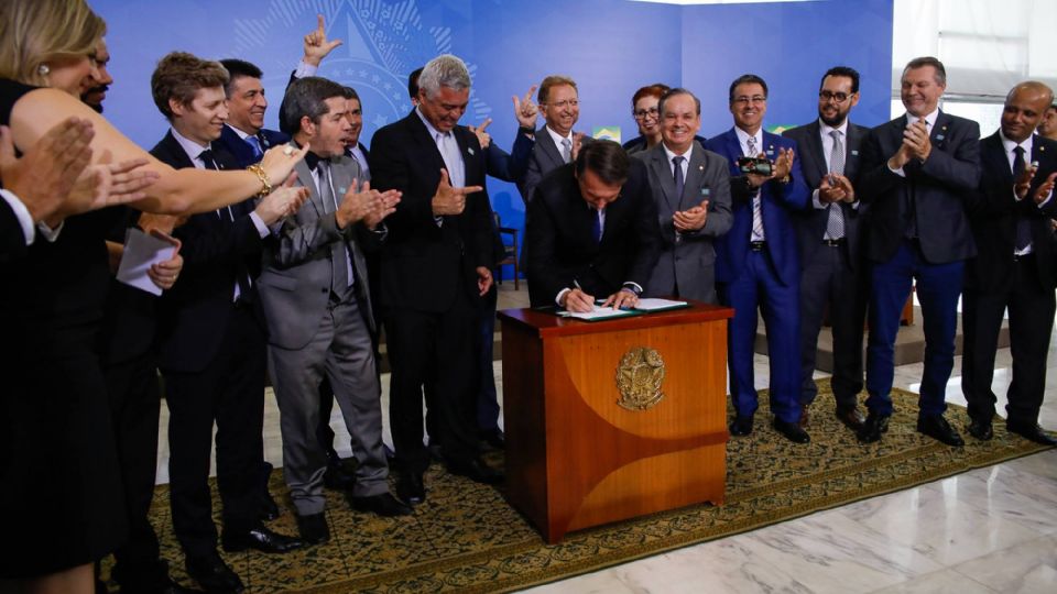 Bolsonaro com parlamentares da base na assinatura do decreto das armas de colecionadores (Foto: Carolina Antunes/PR)