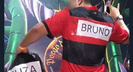 Homem se fantasia de goleiro Bruno do Flamengo carregando saco de lixo onde estaria Eliza Samúdio