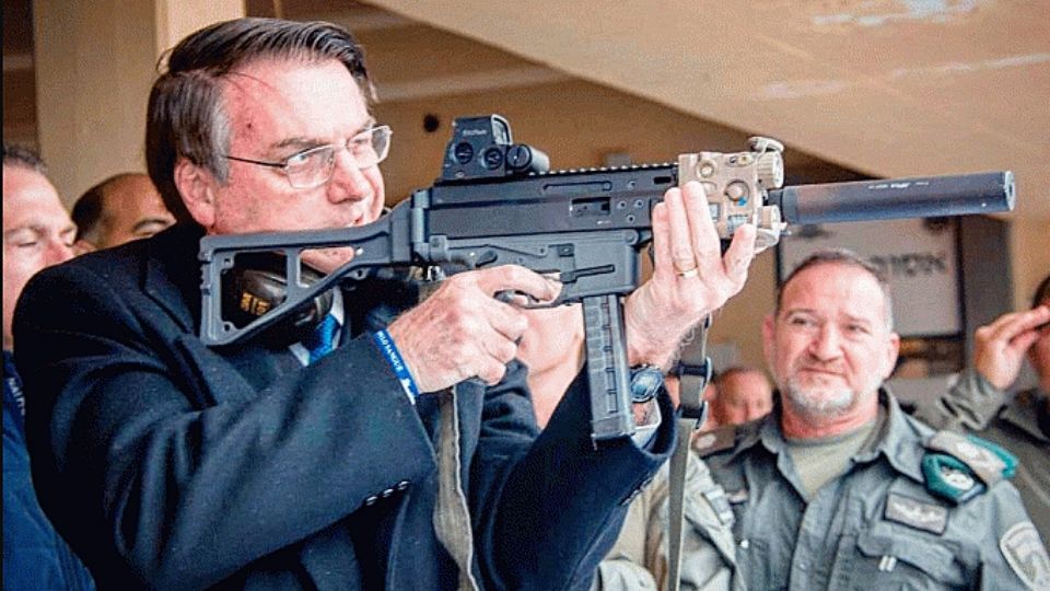 Bolsonaro empunha arma israelense durante visita ao país.