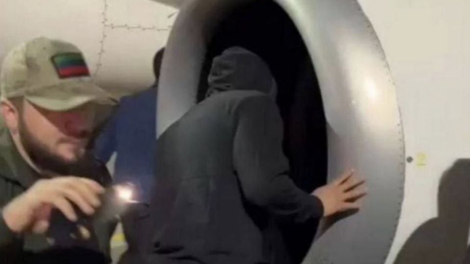 Homem olha em turbina de avião dentro do aeroporto da capital do Daguestão