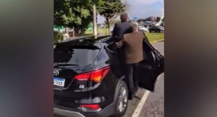 VÍDEO: Bolsonaro anda pendurado em carro e acena para ninguém no RS