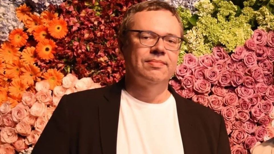 João Emanuel Carneiro, autor de novelas da Globo, rodeado de flores