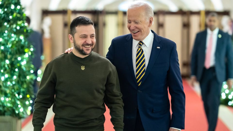 Volodymyr Zelensky e Joe Biden caminham sorrindo na Casa Branca