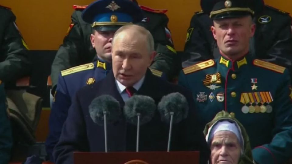 O presidente russo Vladimir Putin em discurso durante parada militar em 2024; ao fundo, oficiais militares uniformizados